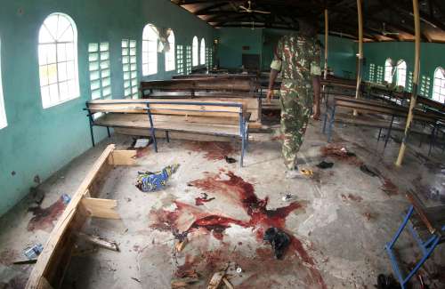 A Kenyan policeman walks inside the African Inland Church after an attack in Garissa