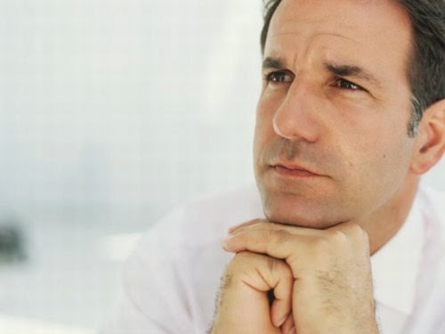 Mature man with hands on chin,looking away,close-up