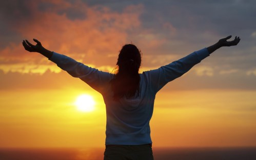 Freedom woman on sunset sky