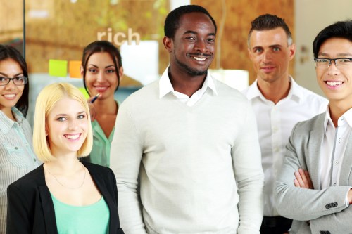 Happy group of co-workers standing in office