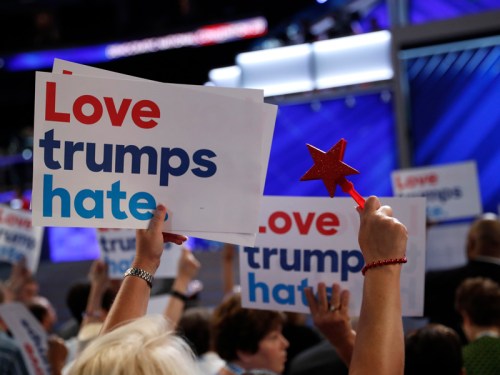 Delegates wave "Love trumps hate" signs towards the podium during the first session at the Democratic National Convention in Philadelphia, Pennsylvania, U.S. July 25, 2016. REUTERS/Mark Kauzlarich - RTSJLN8